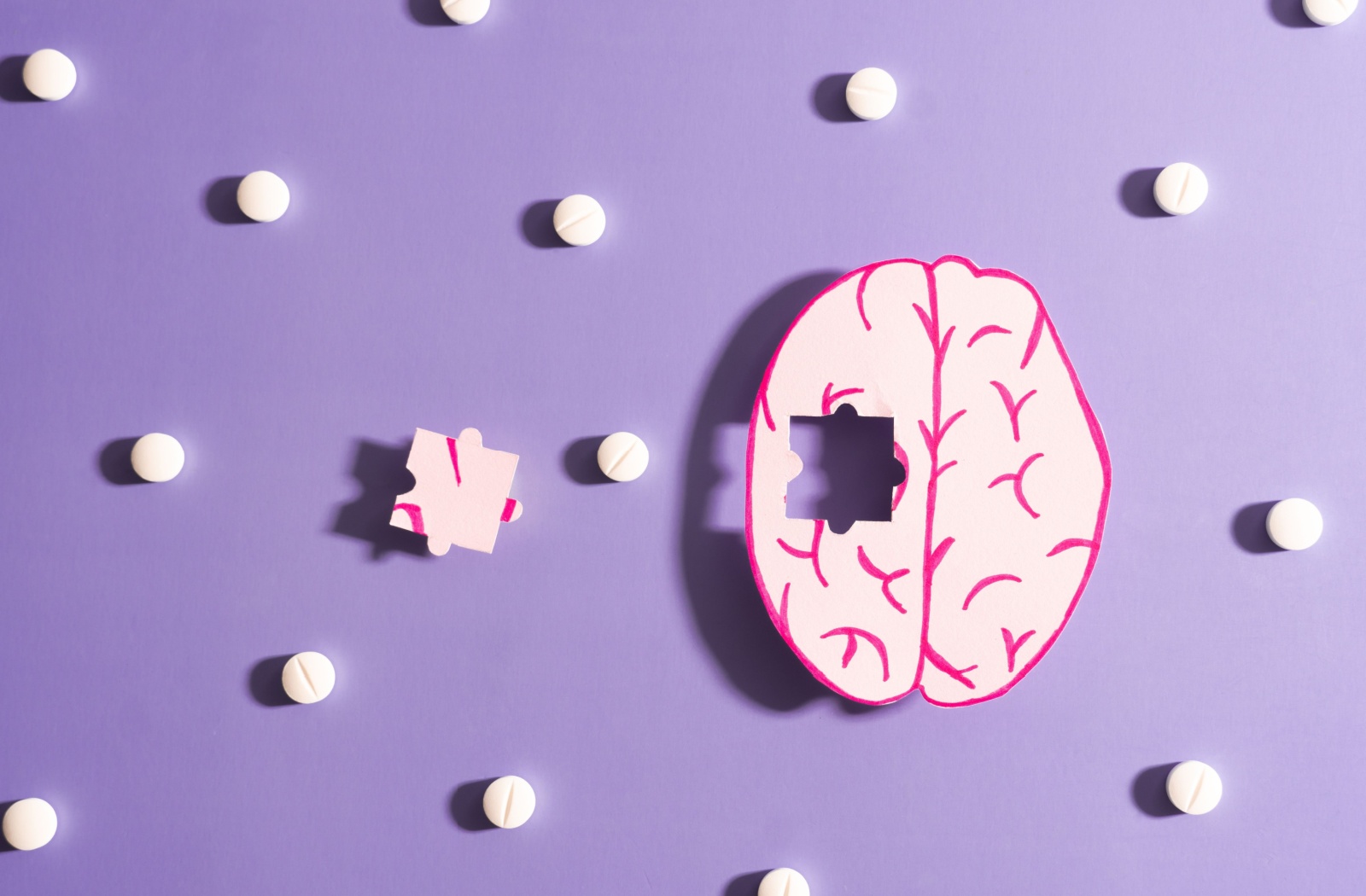 A model of a brain that has a missing puzzle piece, symbolizing dementia, is on a purple background with white dots.