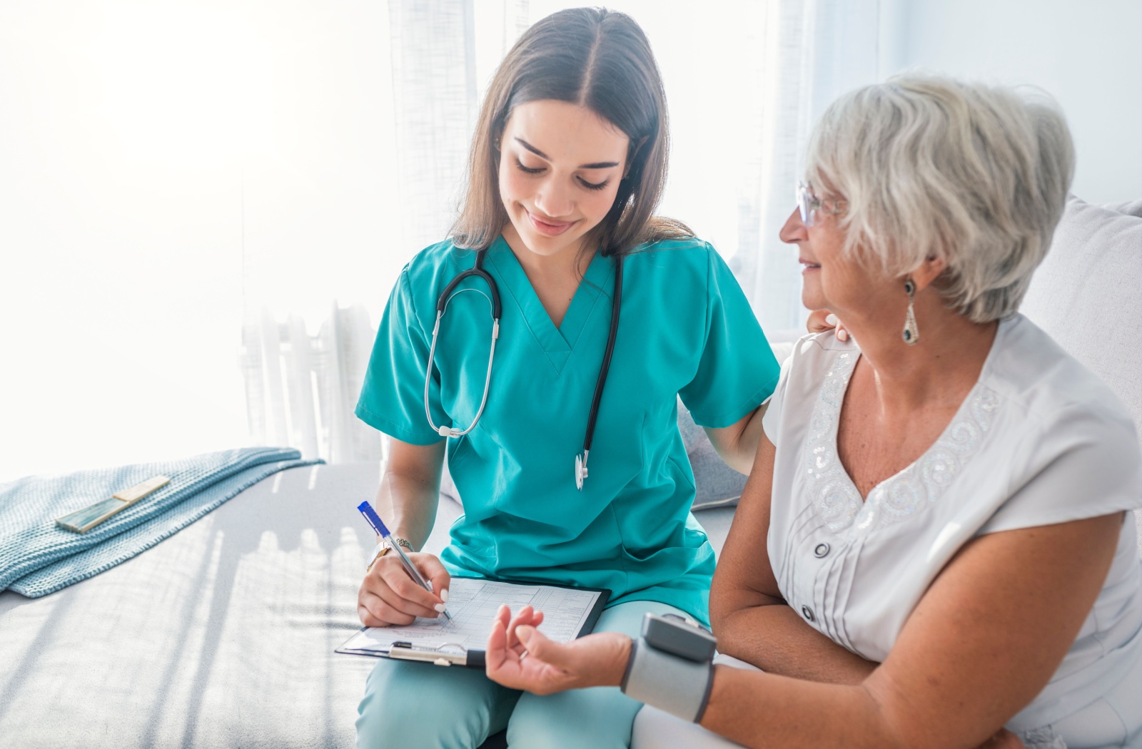 Nurse taking the blood pressure of an elderly woman