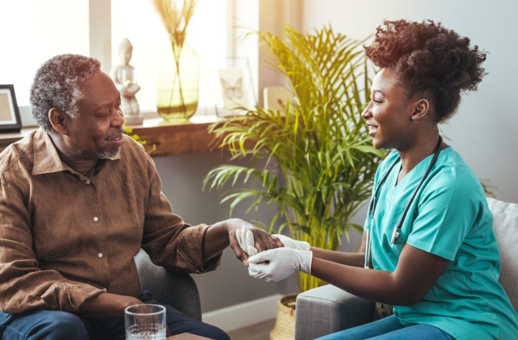 Nurse holding hands and smiling with an elderly man