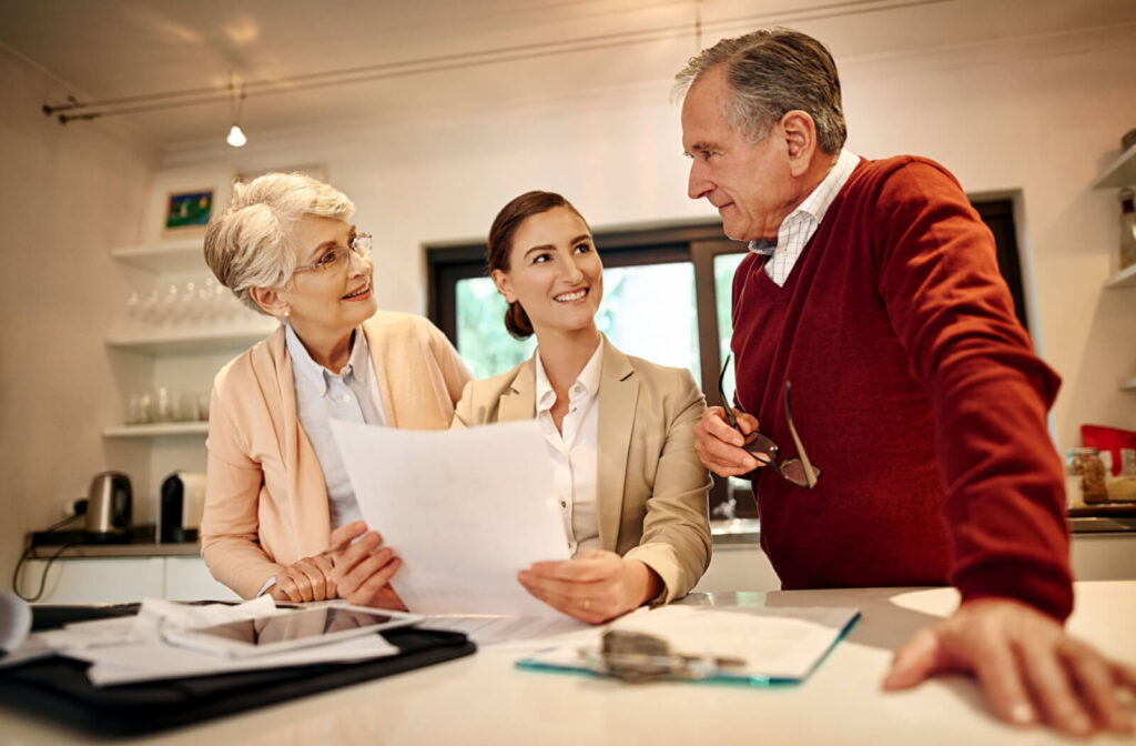 An older couple presenting their adult child with a Power of Attorney document in their home.